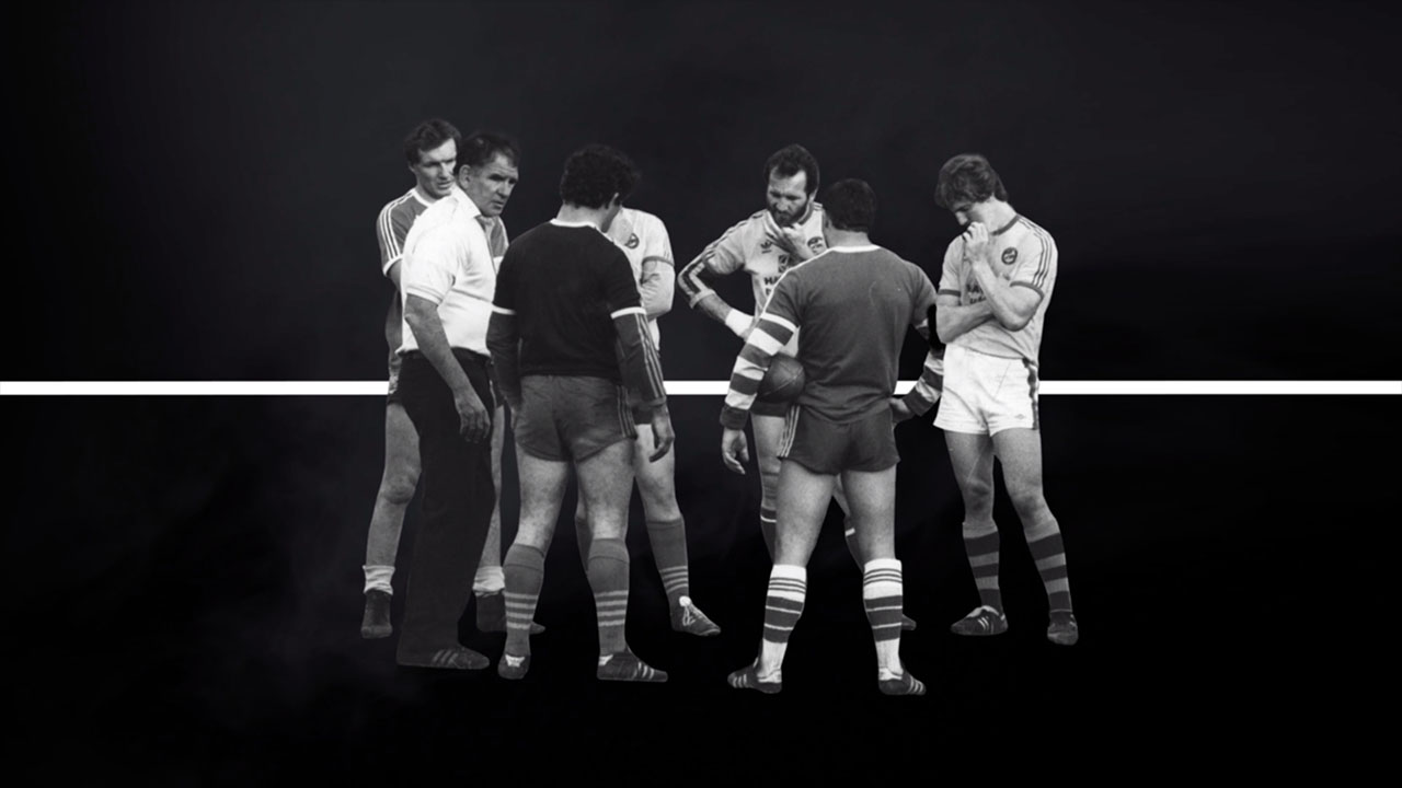 Historic footy players standing in a circle